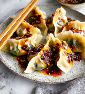 Asian-inspired vegan dumplings with garlic-chili sauce on a ceramic plate