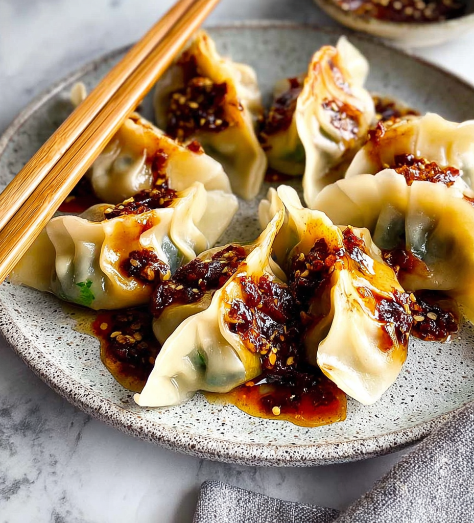 Asian-inspired vegan dumplings with garlic-chili sauce on a ceramic plate