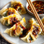 Served Asian-inspired vegan dumplings with garlic-chili sauce